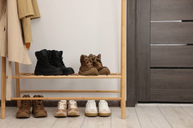 Ayakkabı deposu. Farklı ayakkabıları olan ahşap askılar.