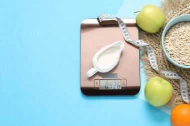 Elektronik mutfak ölçeği, mezura ve açık mavi zemin üzerindeki ürünler, düz zemin. Metin için boşluk