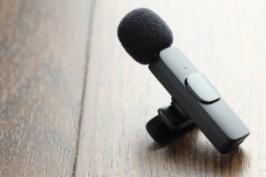 Lavalier mikrofonu ahşap masada, yakın plan. Metin için boşluk