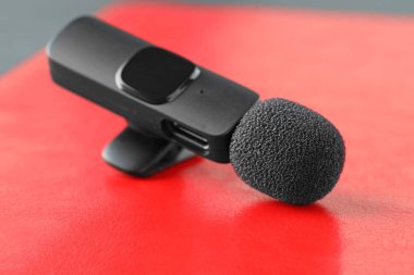 Lavalier mikrofonu kırmızı arkaplanda, yakın plan. Ses ekipmanları