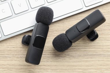 Lavalier mikrofonlar ve klavye ahşap masada, düz yatıyordu.