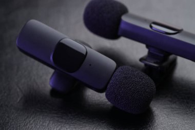 Lavalier mikrofonları siyah masada, yakın plan. Ses ekipmanları