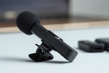 Lavalier mikrofonu gri masada, yakın plan. Ses ekipmanları
