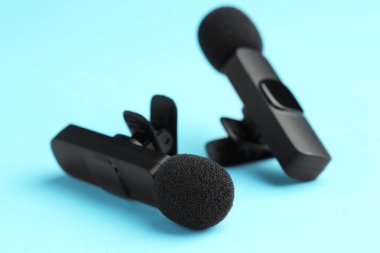 Açık mavi arkaplanda Lavalier mikrofonları, yakın plan