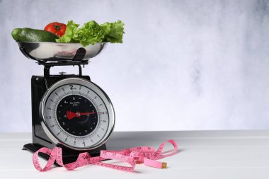 Sebzeli mutfak pulları ve beyaz ahşap masadaki mezura.