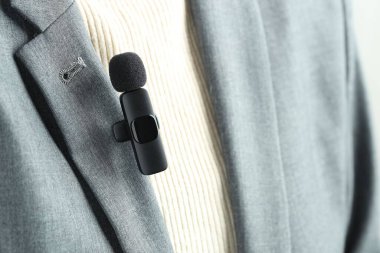 Gömleğinde lavalier mikrofon olan bir kadın, yakın plan.