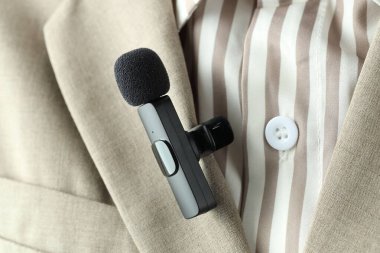 Gömleğinde lavalier mikrofon olan bir kadın, yakın plan.