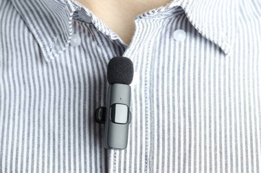 Gömleğine mikrofon takmış bir adam, yakın plan.