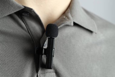 Polo tişörtüne mikrofon takmış bir adam.