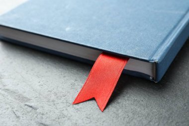 Gri desenli masa üzerinde kırmızı kurdele yer imi olan planlayıcı, yakın plan