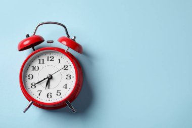 Açık mavi arka planda kırmızı alarm saati, üst manzara. Metin için boşluk