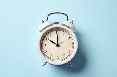 Açık mavi arkaplanda beyaz alarm saati, üst görünüm