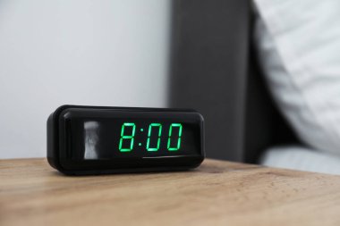 Dijital alarm saat 8 'de kapalı bir masada.