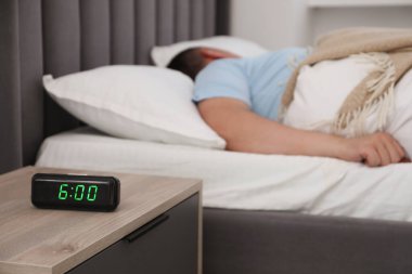 Evde uyuyan adam, dijital alarma odaklan.