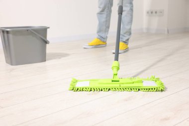 Yerleri mikrofiber paspasla temizleyen kadın, yakın plan.