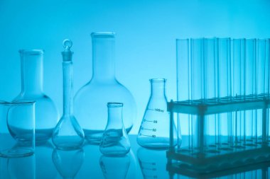 Ayna yüzeyinde açık mavi arkaplana karşı laboratuvar camları