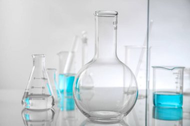 Ayna yüzeyinde ışık arkaplanına karşı laboratuvar camları