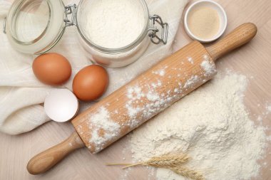Yuvarlanan iğne, un ve yumurta ahşap masada, düz yatıyordu.
