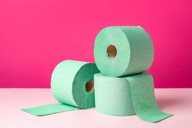 Pembe arka planda yeşil tuvalet kağıdı ruloları. Metin için boşluk