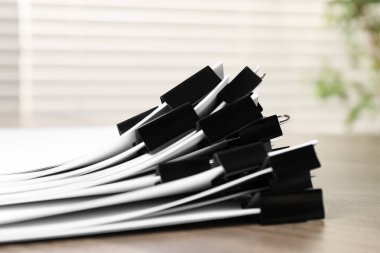 Kapalı masa üzerinde kağıt kağıtları olan ataçlar, yakın plan.