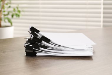 İçerideki masada kağıt parçaları olan ataçlar.