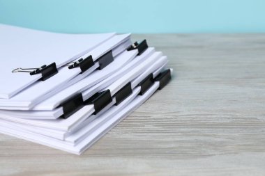 Tahta masanın üzerinde kağıt parçaları olan ataçlar, yakın plan. Metin için boşluk