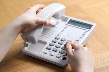 Ahşap masada telefonla arayan kadın, yakın plan.