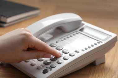 Ahşap masada telefonla arayan kadın, yakın plan.