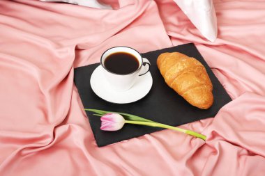 Yatakta nefis kahvaltı ve lale ve ipek çarşaflar.