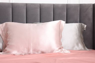 Evde ipek çarşaflı bir yatak.