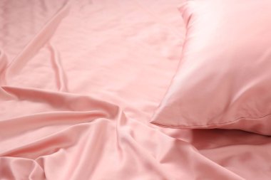 Güzel pembe ipek çarşaflı yatak, yakın plan. Metin için boşluk