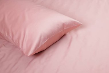 Güzel pembe ipek çarşaflı yatak, yakın plan. Metin için boşluk