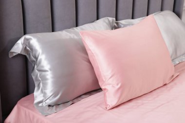 Evde ipek çarşaflı bir yatak.