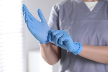 Hastanede eldiven takan tıp çalışanı, yakın plan.