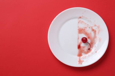 Kırmızı arka planda kirli bir tabak, üst manzara. Metin için boşluk