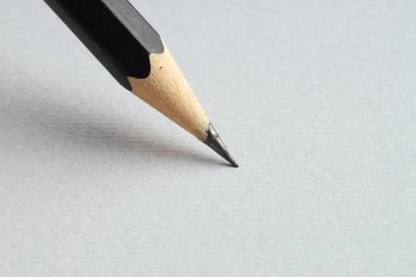 Hafif arkaplanda keskin bir grafit kalem, yakın plan.