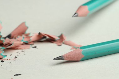 Hafif arkaplanda grafit kalemler ve talaşlar, yakın plan