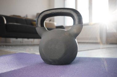 Evdeki spor minderinin üzerinde bir çaydanlık çanı.