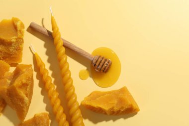 Güzel balmumu mumlar, ballı cips ve bej arka planda balmumu parçaları, düz yatak. Metin için boşluk