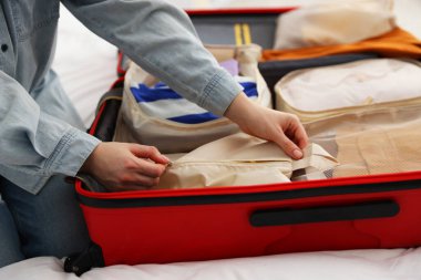 Kadın fermuarlı paketleme küpü valizin içinde, yakın plan.