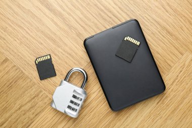 Harici sabit disk, SD hafıza kartları ve hafif ahşap masa üzerindeki asma kilit kombinasyonu, düz uzanma