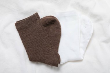 Beyaz battaniyede yumuşak çoraplar, üst manzara.
