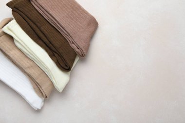 Açık bej arka planda farklı yumuşak çoraplar, üst manzara. Metin için boşluk
