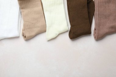 Açık bej arka planda farklı yumuşak çoraplar, üst manzara. Metin için boşluk