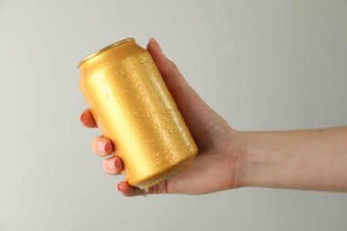 Açık gri arka planda teneke kutusu olan kadın, yakın plan.