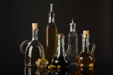 Aynada salata sosları ve zeytinler siyah arka planda