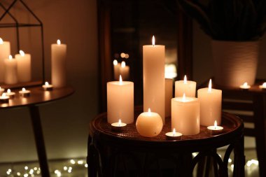 Karanlık odada yanan parafin mumları.