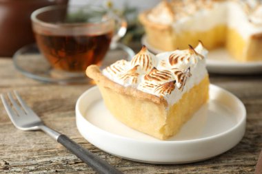 Kahverengi kremalı ve çatallı lezzetli bir turta, ahşap masa, yakın plan.