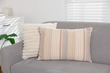 Odadaki kanepede yumuşak dekoratif yastıklar.