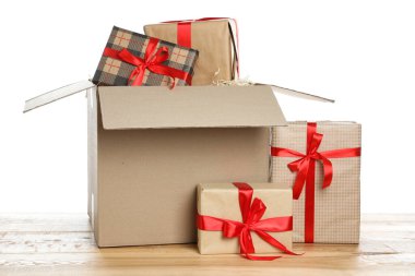 Beyaz arkaplana karşı ahşap masanın üzerinde hediye kutuları olan paket